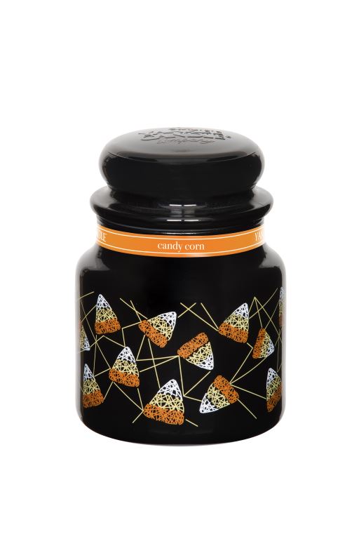 A black candle, with an orange label, and pictures of Candy Corn on it, on a white background.