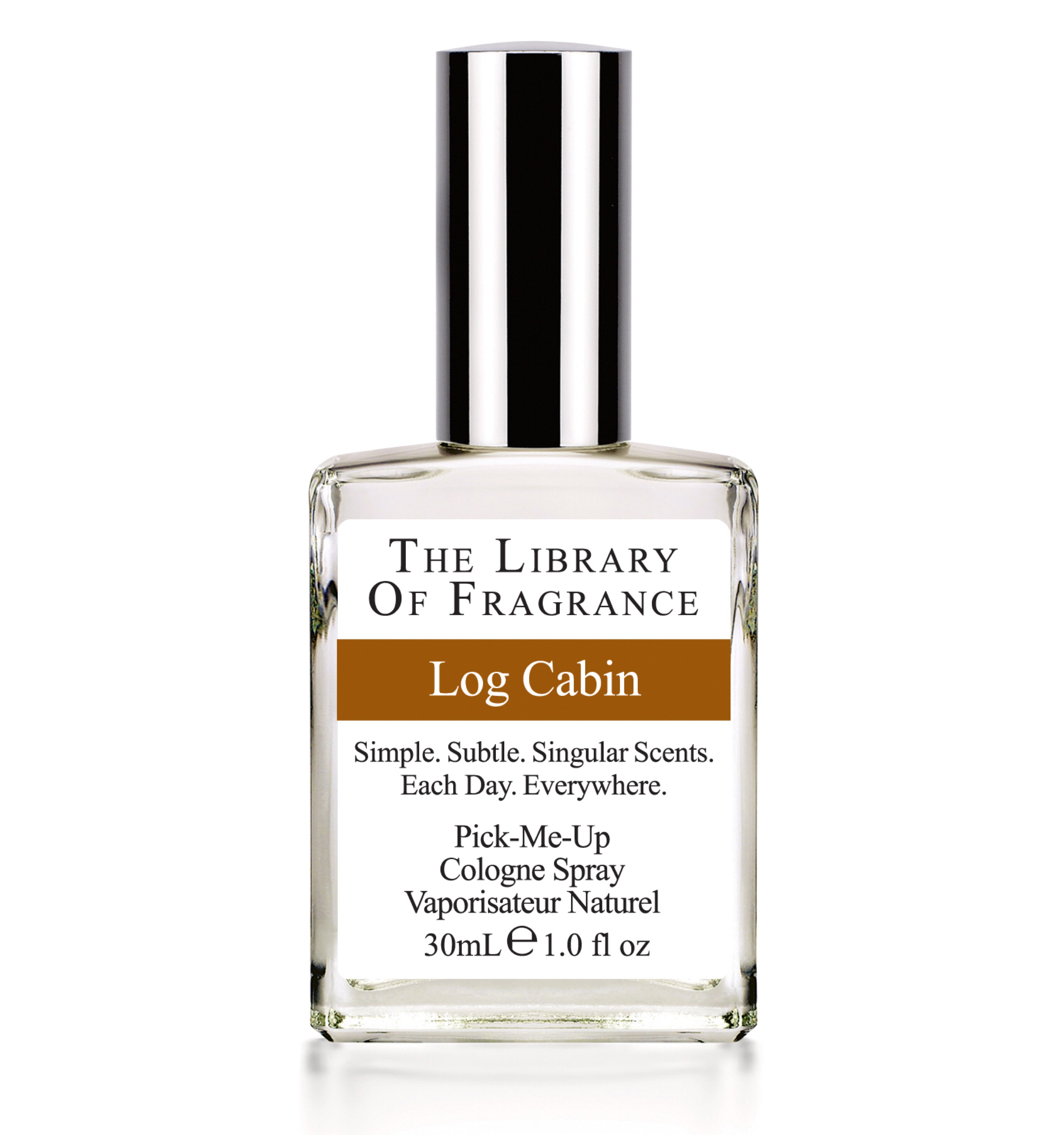 A glass perfume bottle with The Library Of Fragrance written on a white label, and Log Cabin written on a brown strip, on a white background.