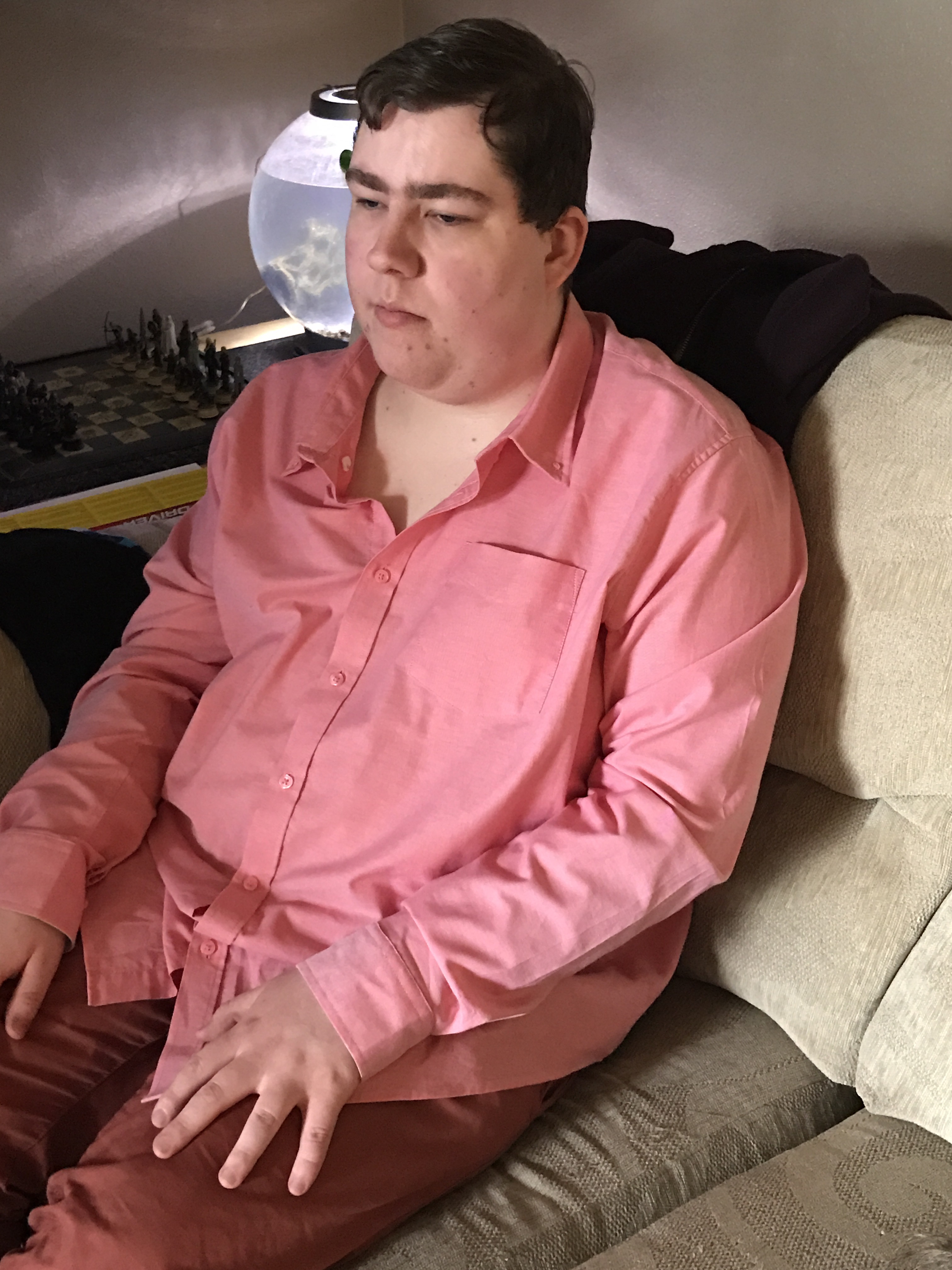 A light pink shirt with an open collar, on a grey background.