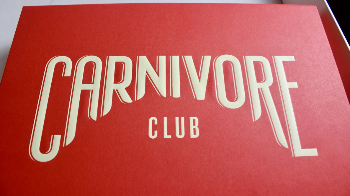 A large bright red rectangular Cardboard box that has Carnivore written in large white capital letters, and club written in smaller white capital letters on it, on a white background.