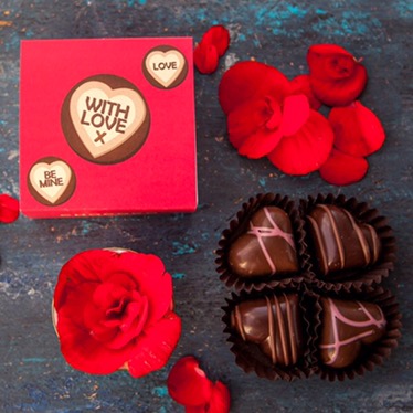 Three sweets saying things like be mine in white icing in a row on a red background, a picked apart Rose on a black background, a full Rose on a black background, and four heart shaped chocolates in a circle on a black background.