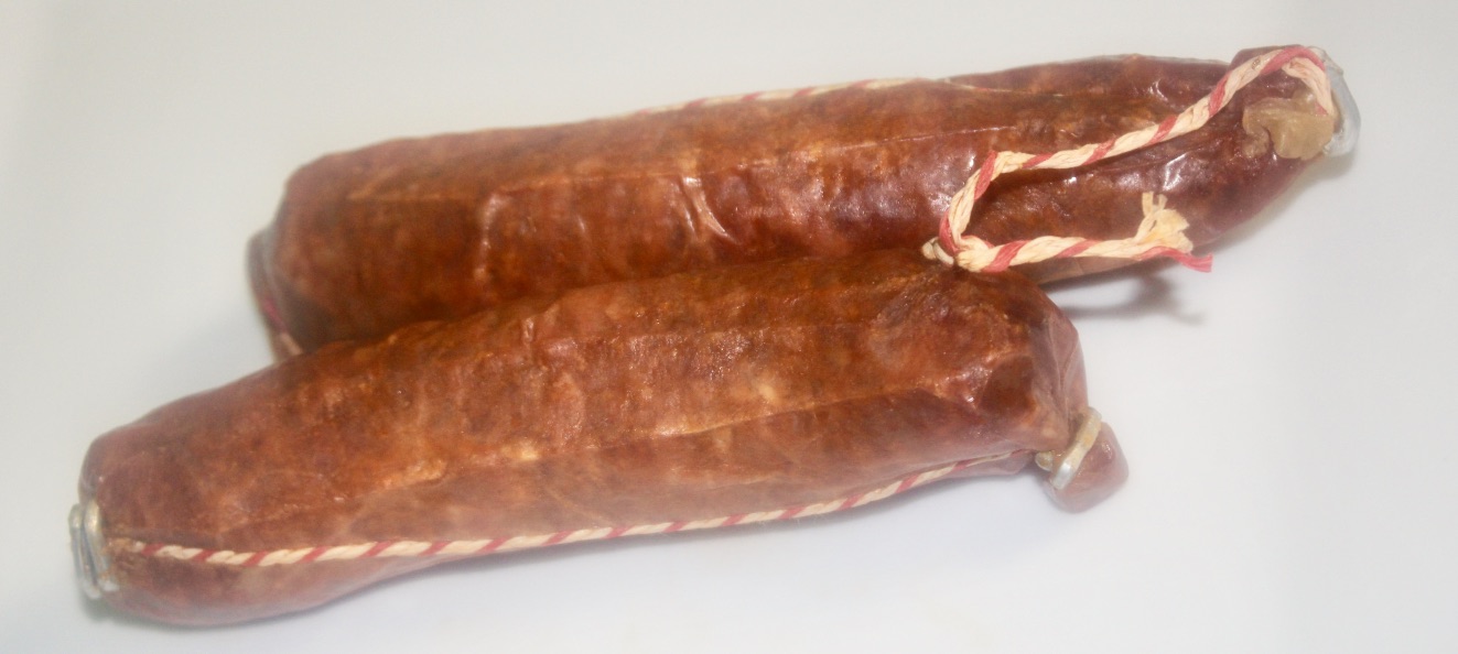 Two long red chorizo sausages with white on the edges of them, on a white background.