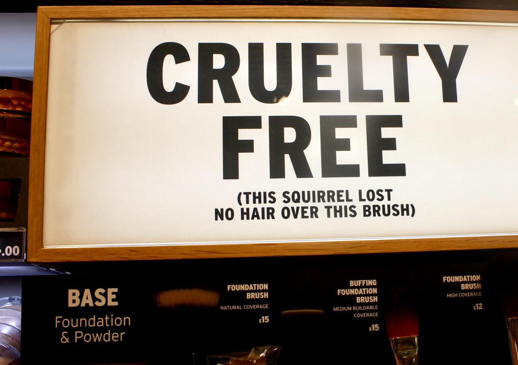 A long rectangular white board that has cruelty free written in bold black writing and this squirrel lost no hair over this brush in smaller bold writing on it, on a bright background.