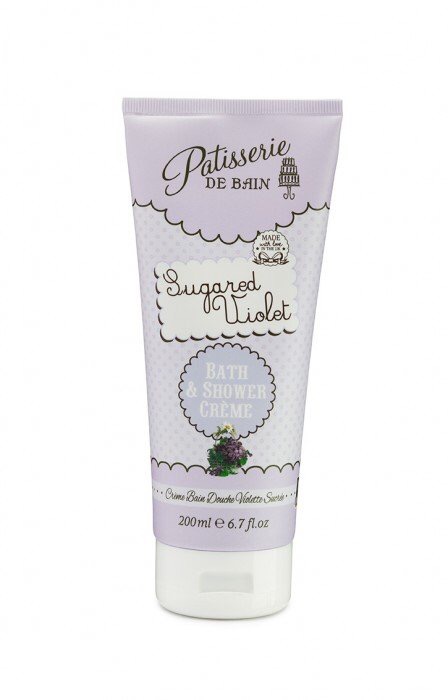 A tall white cone shaped bottle that has Patisserie De Bain and sugared violet written in pink and purple writing inside a light purple bubble and Shower Creme written in white writing inside a blue bubble, on a white background.