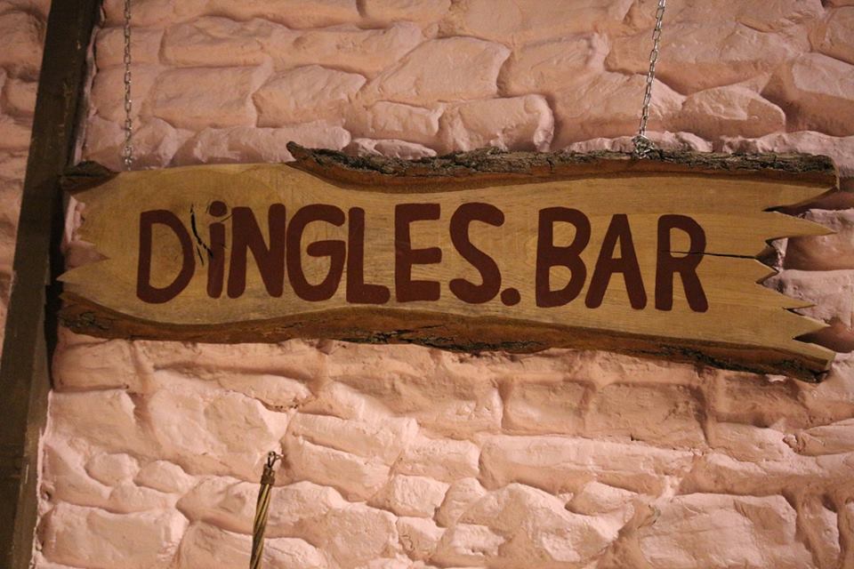 Some Grey Bricks that have Dingles' Bar written on them in bold underlined black writing, on a light background.