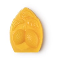 A large bright yellow house shaped block of soap that has some spots and stars engraved into it, on a white background.