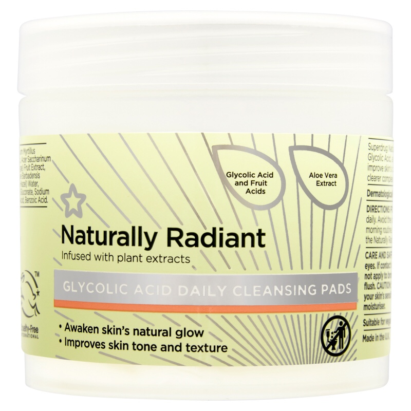 A slightly golden short cylindrical plastic tub that has a picture of a small pink star, Superdrug written in cursive pink writing, naturally radiant written in small black writing, and Glycolic Acid Pads 60 improve skin's tone and texture written in small white writing on it, on a light background.