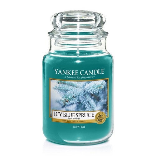 A tall cylindrical Glass Jar full of some turquoise coloured wax with a label that has Yankee Candle written in black writing, Icy Blue Spruce written in black writing, and a picture of a Tree Branch covered in some Snow on it, on a white background.