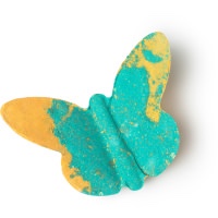 A butterfly shaped bath bomb with some orange tipped green wings, on a white background.
