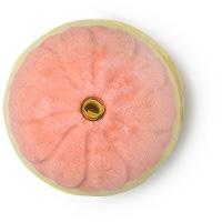 A bright yellow spherical shaped bath bomb with an orange tipped yellow petal design on it, on a white background.