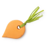 A large block of carrot shaped Orange Soap that has some green straw coming out of the top of it, on a white background.