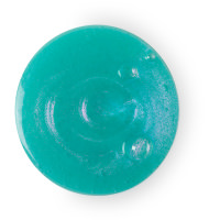 A small circular puddle of bright turquoise shower gel with some little pieces of bright silver and pink glitter in it, on a white background.