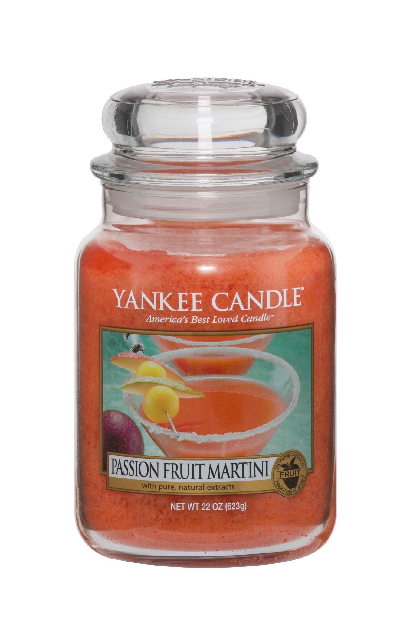 A tall clear glass jar with a picture of a Martini on the label, full of pink wax, on a green background.