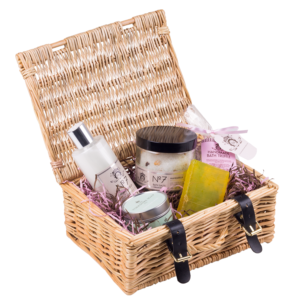 A selection of glass bottles, resting in a tan square wicker basket with black leather straps.