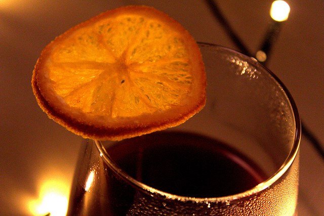 #BlindGuyAdventures | Afternoon Tea, Facial Hair, and so much Wine. A clear glass full of dark coloured red wine, with an orange slice of fruit floating around the top of the glass, on a wooden background