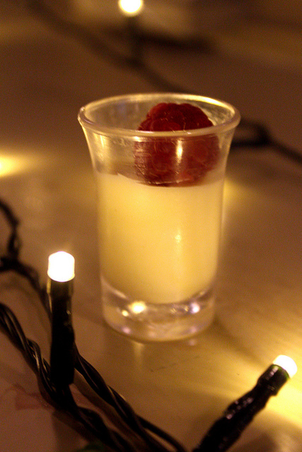Mistletoe and Mulled Wine | Browns Leeds Festive Showcase A clear glass full of White Chocolate Moose, with a Raspberry on the top, on a wooden background.