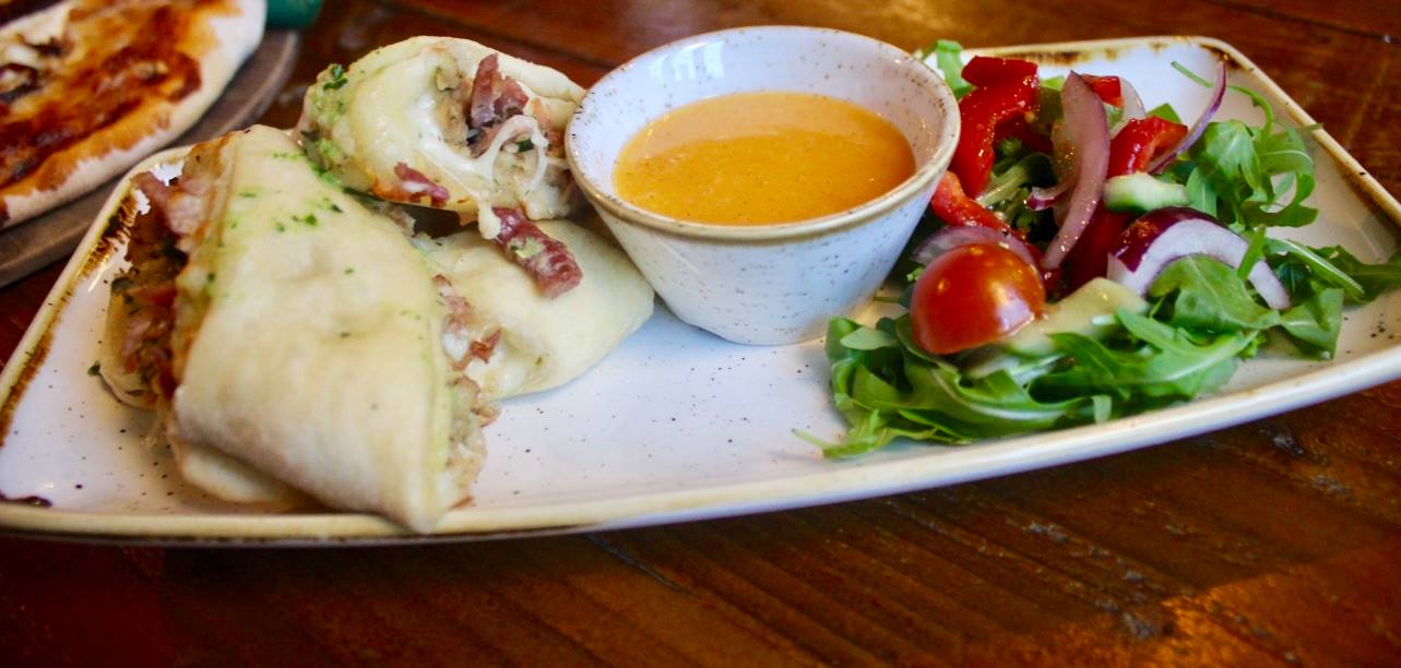 Potting Around The Winter Garden | The Potting Shed Bingley Winter 2016 Menu Some slightly golden dough balls, with a dark Pork filling, and a bright gold aioli in a white bowl, and a red and green salad, on a white rectangular plate, on a dark wooden background.