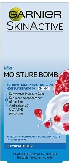 A tall thin grey Garnier box with Moisture Bomb 3 in 1 written in dark text, with some light blue and dark blue sections, Berries, and some white cream on the box, on a white background.