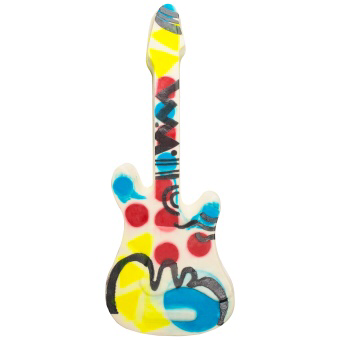 A long guitar shaped soap with flecks of purple, white, yellow and red all over it, on a white background.
