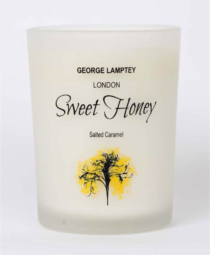 #BlindGuyAdventures | Luke Let Loose In London A tall white box that has George Lamptey London written in black writing, Sweet Honey written in cursive pink writing, salted caramel written in smaller Pink writing and a picture of a small brown weathered tree on it, on a white background.