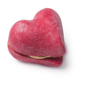 Cherish The Ones You Love | Lush Valentines Day 2018 Range Two medium sized cherry red heart shaped bubble bars sandwiched together with some bright gold shimmering butter cream in the middle of them, on a white background.