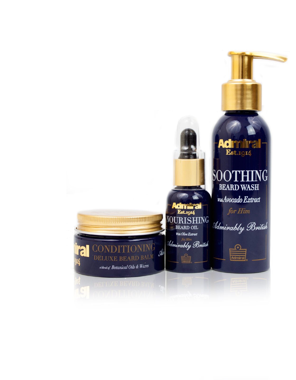 A tall plastic cylindrical black bottle with a gold pump lid, a short cylindrical black bottle with a gold pipette lid, and a cylindrical black plastic tub with a gold foil lid sat on a light brown cardboard tray inside a rectangular blue box that has Admiral Grooming Beard Grooming Trio written in bold gold writing, and Soothing Beard Wash, Nourishing Beard Oil, and Conditioning Deluxe Beard Balm written in smaller gold writing on it, on a white background.