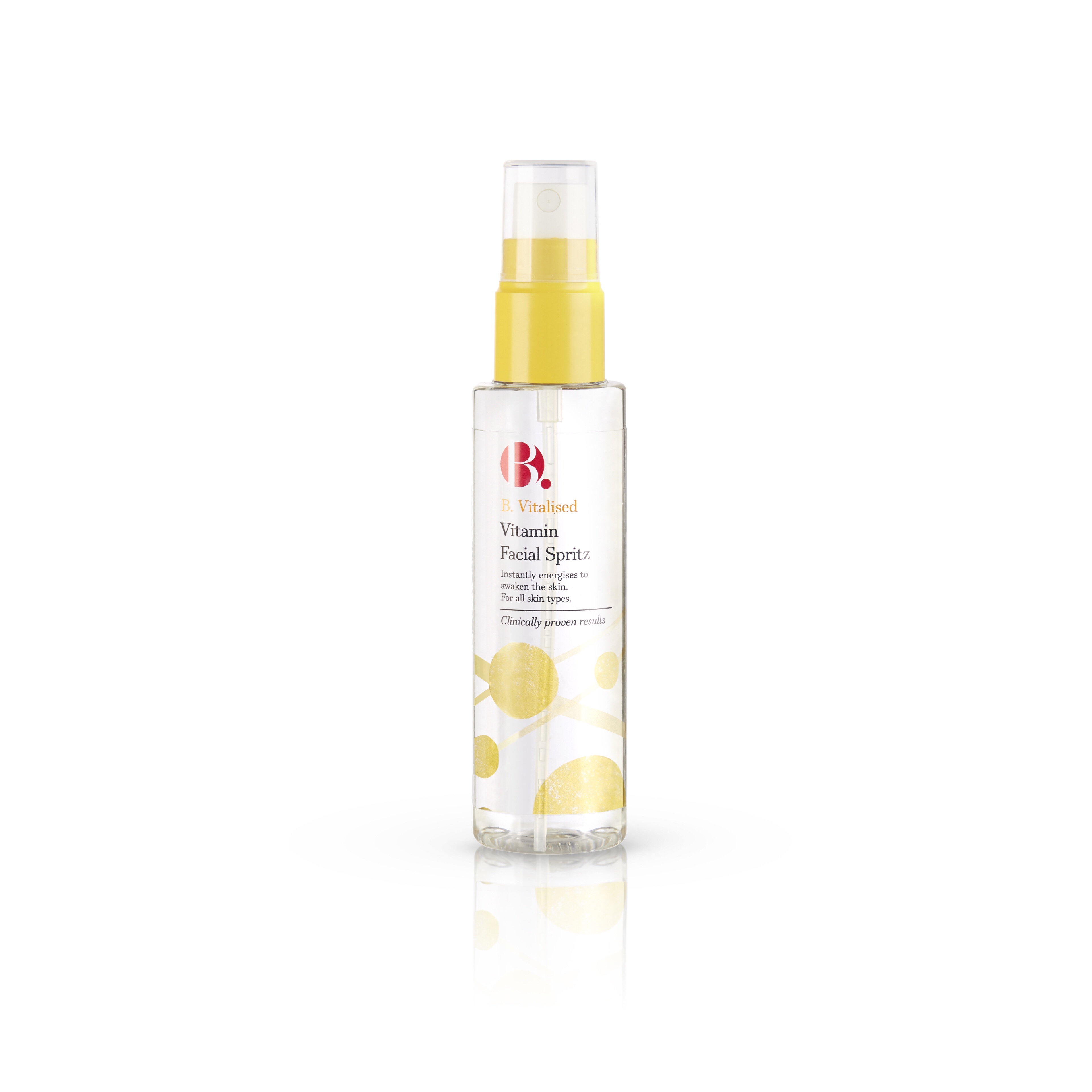 A tall cylindrical clear plastic spray bottle with a white and yellow label that has B. Vitalised Vitamin Spritz written in black writing on it, on a white background.