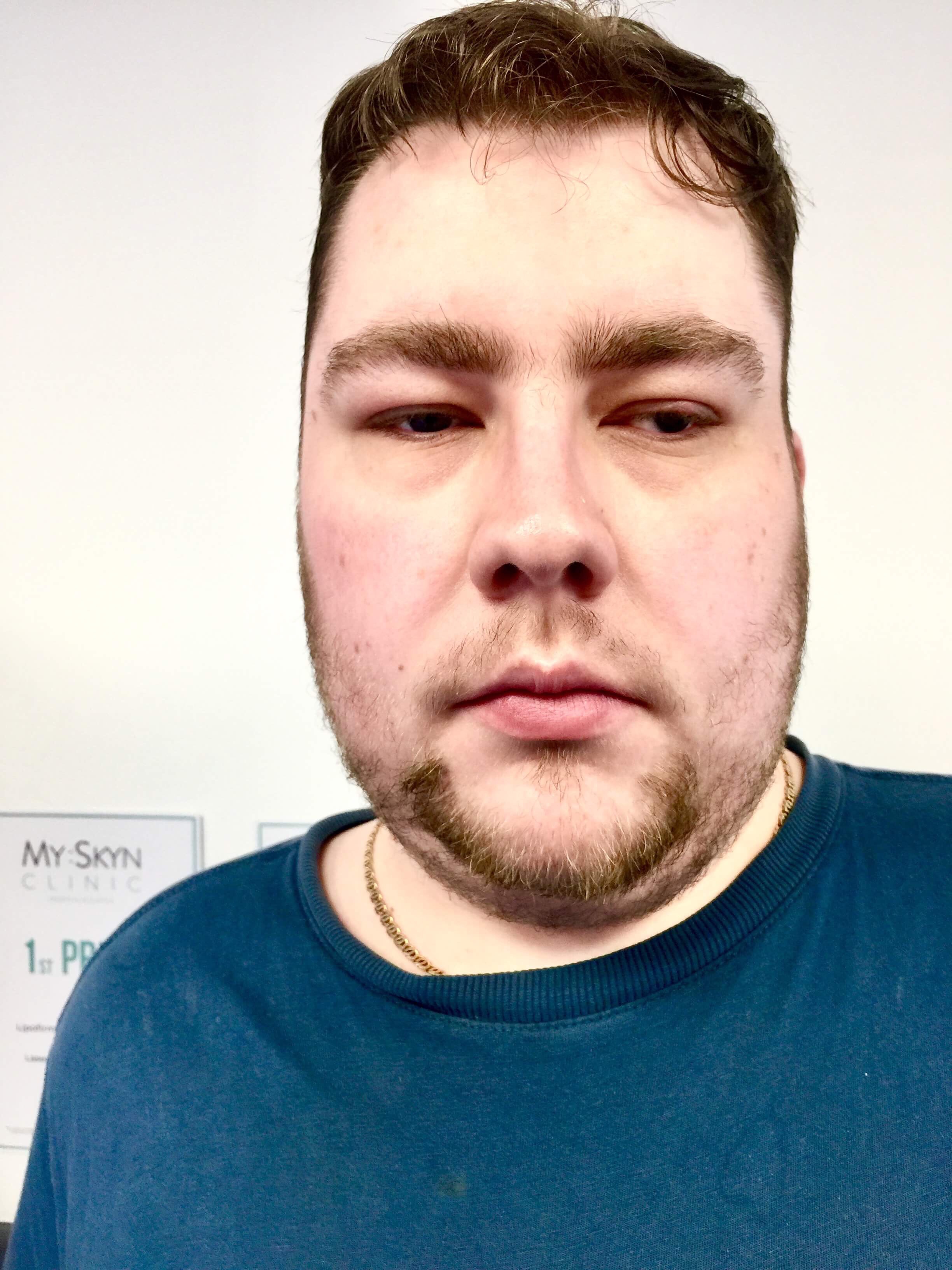 me wearing a black T-Shirt stood against a white wall, on a white background.