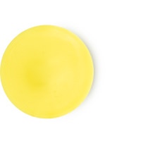 A circular blob of yellow wax, on a white background.