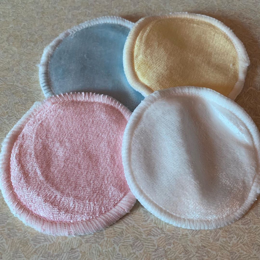 A large circular piece of bright pink material next to a large circular piece of bright white material, a large circular piece of bright yellow material, and a large circular piece of light blue material, on a white background.