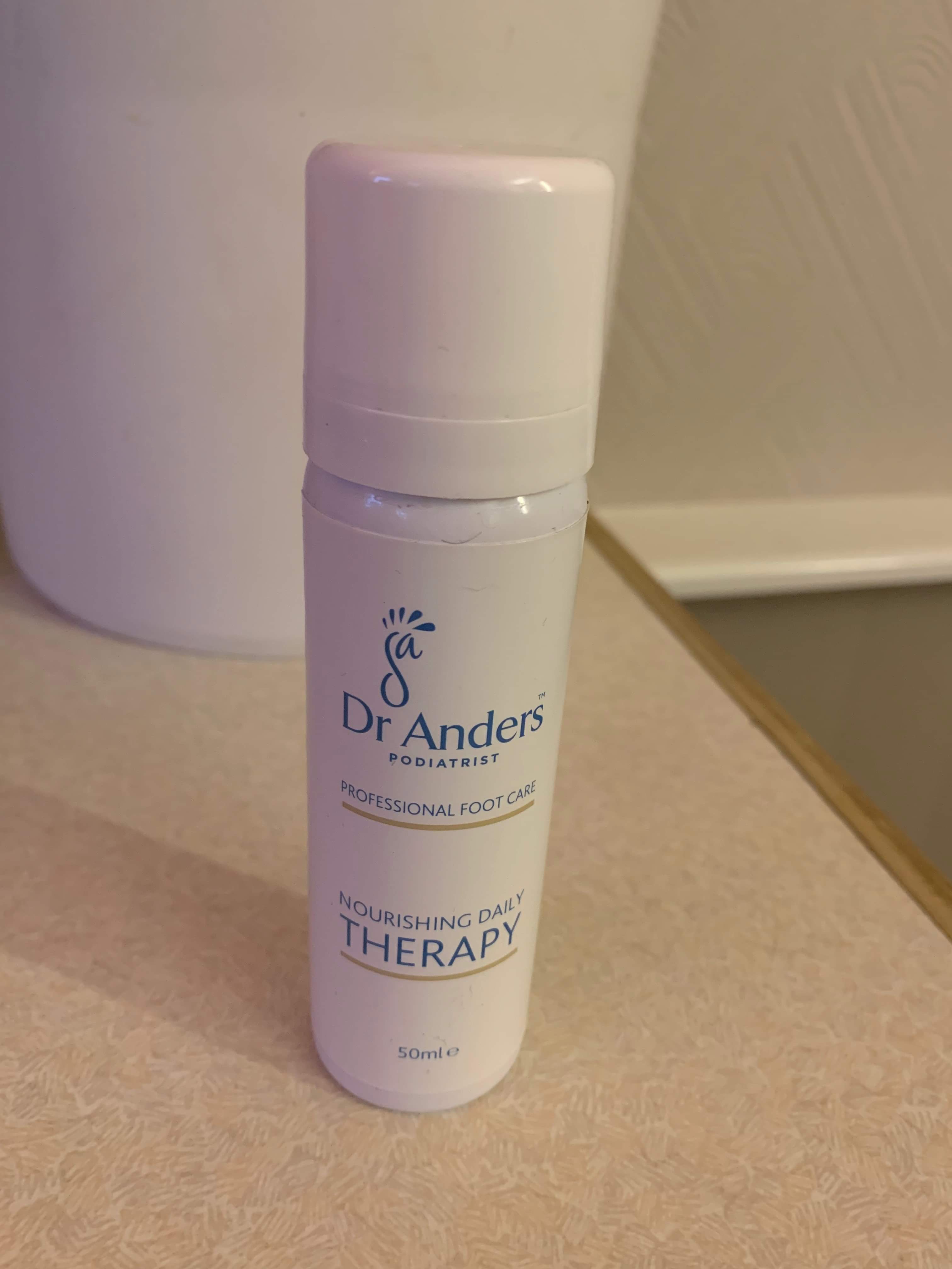 Finally Seeing The Doctor About My Feet | Dr Anders Foot Care | Gifted A short cylindrical white metallic canister with a white plastic lid that has Dr Anders nourishing Daily therapy written in bold blue writing on it, on a white background.