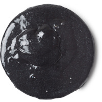 A small circular puddle of black shower slime with some little pieces of grit in it, on a white background.