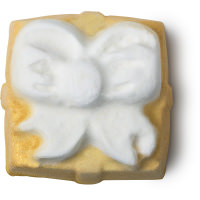 Celebrate Good Times, Come On! | Lush Golden Wonder Bath Bomb & Celebrate Body Spray A large square shimmering gold wrapped present shaped bath bomb covered in some gold lustre, on a white background.