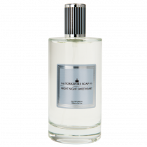 A tall cylindrical clear glass bottle full of some clear liquid with a silver and blue lid and a black label that has The Yorkshire Soap Company Night Night Sweetheart Eau De Parfum written in bold blue writing on it, on a white background.