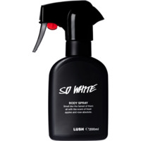 A tall black plastic kitchen spray bottle with a black label that has Lush So White Body Spray written in bold white writing on it, on a white background.