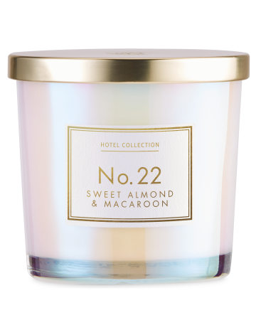 The Sweet Smell Of Winter | Aldi Hotel Collection Sweet Almond & Macaroon & Rose Noir Candles A medium cylindrical clear glass jar full of some bright white wax with a shiny gold metal lid and a white label that has Aldi Hotel Collection Sweet Almond & Macaroon Candle written in bold gold writing on it, on a white background.