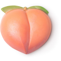A large circular bright pink Peach shaped block of soap with a green stork coming out of the top of it, on a white background.