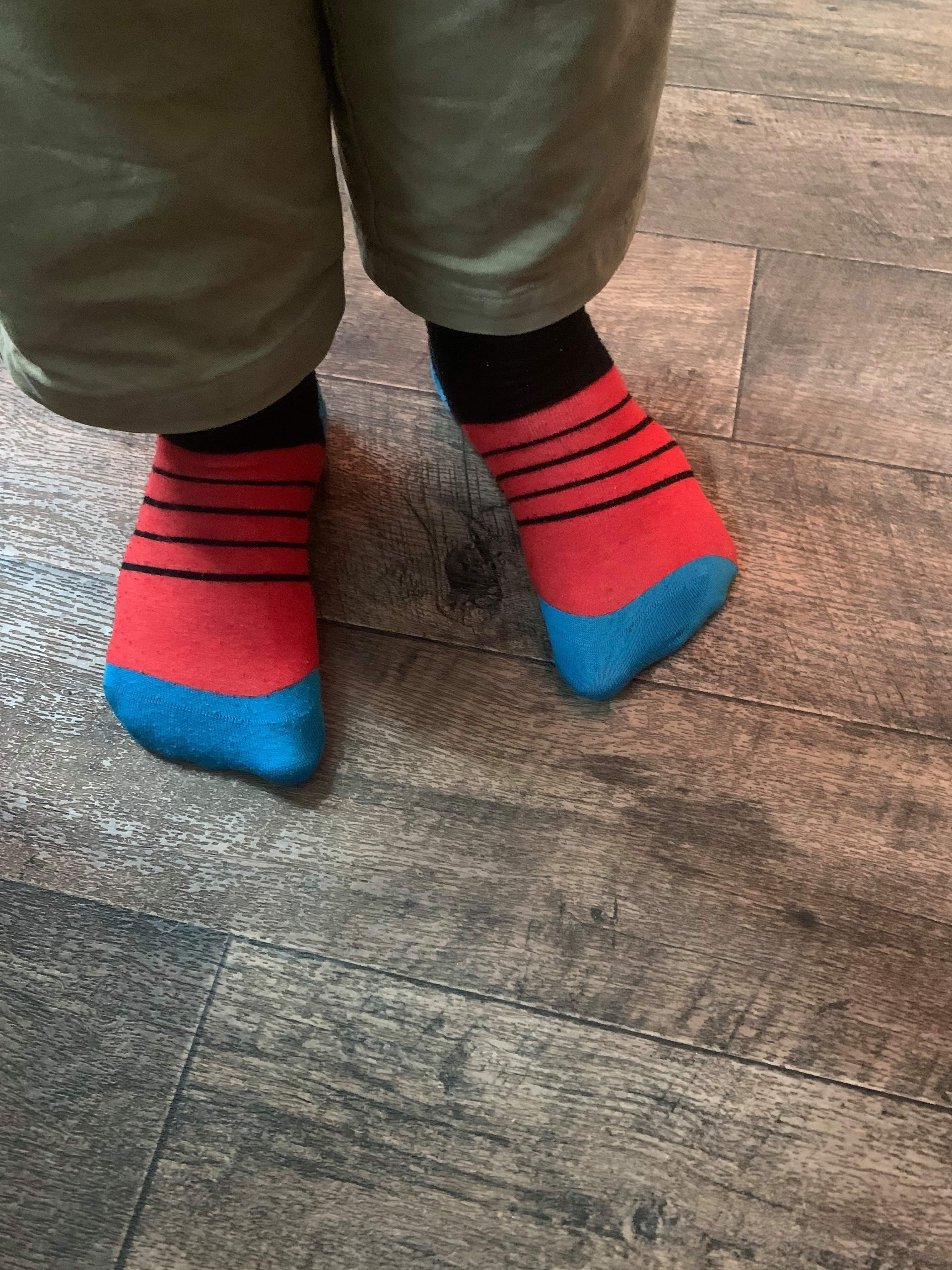 Me wearing a pair of dark red and black striped socks, on a white background.
