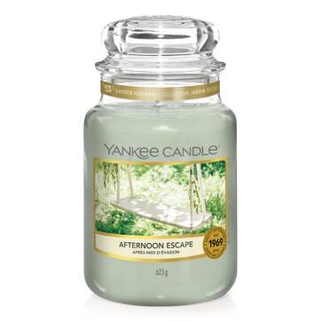 My Little Escape From The World | Yankee Candle Garden Hideaway Collection A tall glass jar full of some bright green wax with a label that has Yankee Candle written in black writing, Afternoon Escape written in black writing, and a picture of a homemade garden swing on it, on a white background.