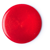 A small circular puddle of shimmering dark orange shower gel, on a white background.