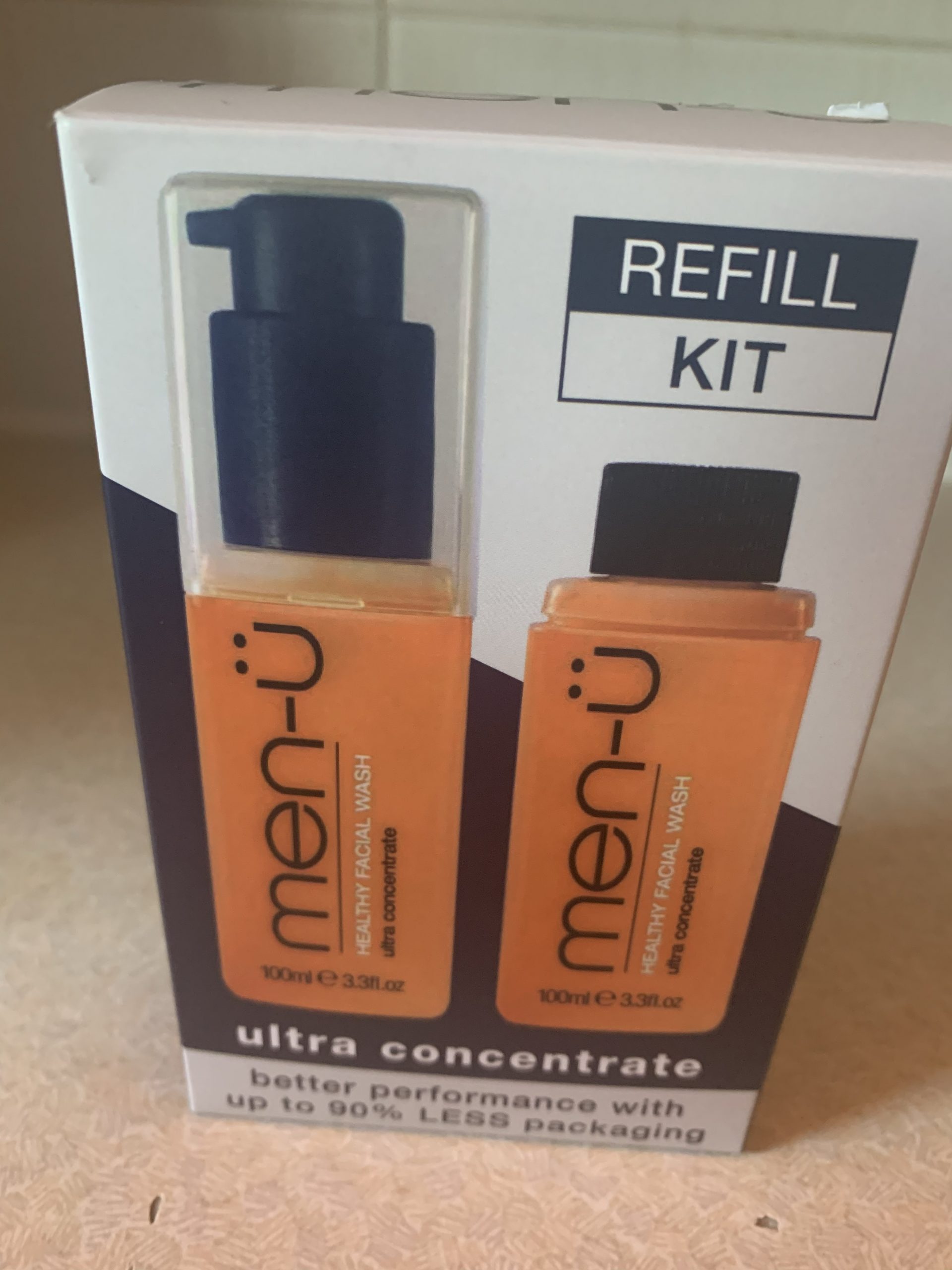 A large rectangular navy and white blue cardboard box that has Men-ü Refill Kit - Healthy Facial Wash written in bold white writing on it, on a white background.