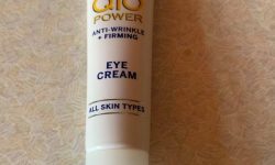 A short flat conical white plastic tube that has Nivea written in bold blue writing and Q10 Power Anti-Wrinkle + Firming Eye Cream written in bold yellow writing on it, on a white background.