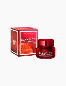 A short cylindrical bright red glass jar with a bright red lid that has Glam Glow Good In Bed™ Passionfruit Softening Night Cream written in bold white writing and a picture of a bright white star on it next to a bright red octagonal shaped cardboard box that has Glam Glow Good In Bed™ Passionfruit Softening night cream written in bold white writing on it, on a white background.