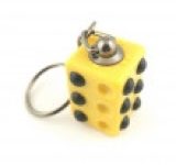 A small rectangular plastic twistable cube keyring that has some brown braille dots on it and a silver metal keychain attached to the top of it, on a white background.