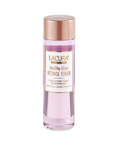 A tall cylindrical clear plastic bottle full of some translucent purple liquid with a bright gold lid that has Aldi Lacura Healthy Glow Glycolic Toner written in bold black writing on it, on a white background.