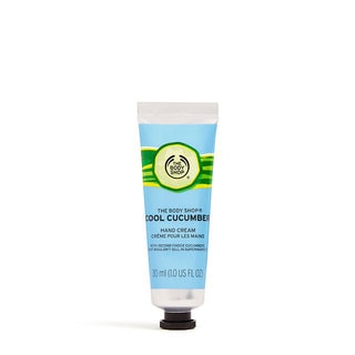 A small thin conical silver plastic tube with a dark green lid that has The Body Shop Cool Cucumber Hand Cream written in dark green writing and a picture of a large bright green cucumber on it, on a white background.