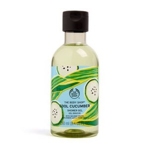 A tall cylindrical clear plastic bottle full of some pale turquoise liquid with a dark green lid and a bright green label that has The Body Shop Cool Cucumber Shower Gel written in dark green writing and some pictures of some bright green cucumbers on it, on a white background.