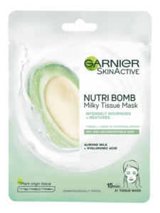 A tall rectangular bright white plastic pouch that has Garnier written in bold black writing, Nutri Bomb Almond & Hyaluronic Acid Tissue Mask written in smaller black writing, and a picture of a large circular puddle of bright white milk on it, on a white background.