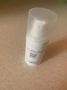 A short cylindrical white plastic bottle that has Primark X Alex Steinherr Sleep Spa Every Night Eye Mask written in bold black writing on it, on a white background.