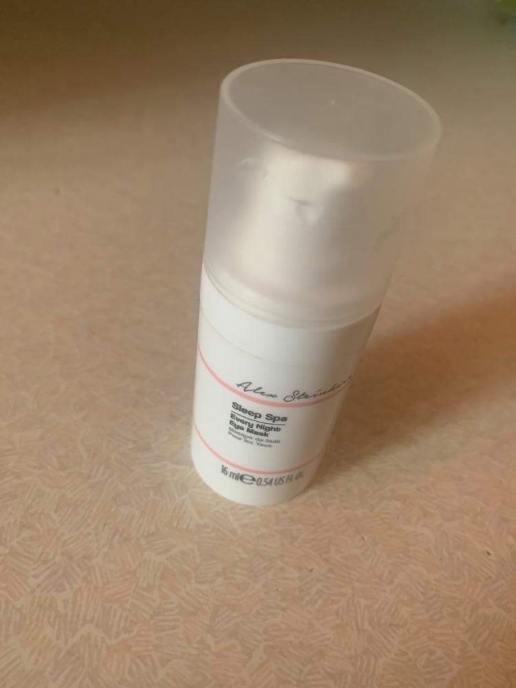 A short cylindrical white plastic bottle that has Primark X Alex Steinherr Sleep Spa Every Night Eye Mask written in bold black writing on it, on a white background.